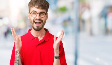 Üzerinde gözlük takan genç yakışıklı adam deli kutluyor arka plan izole ve silah ile başarı için yükseltilmiş ve açık gözleri heyecanlı çığlık hayrete düşürdü. Kazanan kavramı