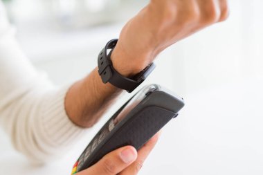 Ödeme metod olarak elektronik saat kullanarak adam yakın. Swiping