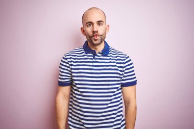 Sakallı genç kel adam pembe izole arka plan üzerinde rahat çizgili mavi t-shirt giyen dudakları, çılgın ve komik jest ile balık yüz yapma. Komik ifade.