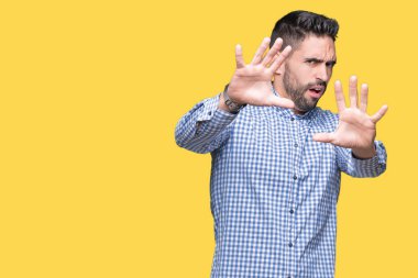 Genç yakışıklı adam şokta bağırarak korkuyor ve dehşet korku ifade dur hareketi el ile ile izole arka plan üzerinde. Panik kavramı.