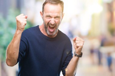 Gülümseyen ve başarı için çığlık orta yaş ağarmış üst düzey adam izole arka plan çok mutlu ve heyecanlı kaldırdı, silah ile kazanan jest yapıyor. Kutlama kavramı.