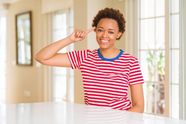Evde Genç güzel afro-amerikan kadın tek parmak, harika bir fikir ya da düşünce, iyi bellek ile baş işaret gülümseyerek