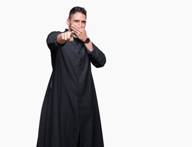 Genç Hıristiyan rahip izole üzerinde arka plan sizin parmak el kamerasıyla ağzına, utanç ifadesi işaret eden gülme