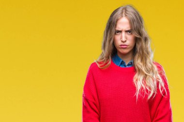 Sorunu nedeniyle izole arka plan şüpheci ve sinir, papatyanın üzgün üzerinde kış kazak giyen güzel genç sarışın kadın. Negatif kişi.