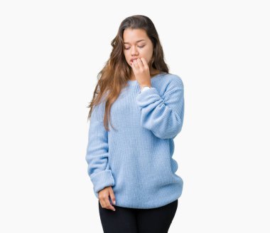 Stresli ve gergin ile izole arka plan üzerinde mavi kış kazak giyen genç güzel esmer kadın tırnak ısırma dudaklarından eller. Anksiyete sorunu.