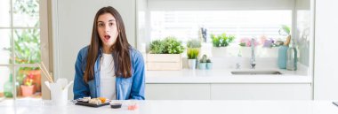 Teslim suşi yemek güzel genç kadın geniş açılı resim korkmuş ve sürpriz ifade ile şok, korku ve heyecanlı yüz.