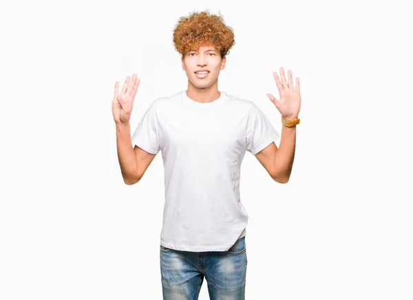 年轻英俊的非洲头发男子穿着休闲的白色 T恤显示和手指 而微笑着自信和快乐 — 图库照片