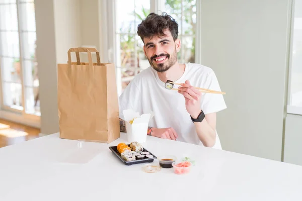 Młody Człowiek Jedzenia Sushi Asian Food Makaron Pomocą Choopsticks Odbioru — Zdjęcie stockowe