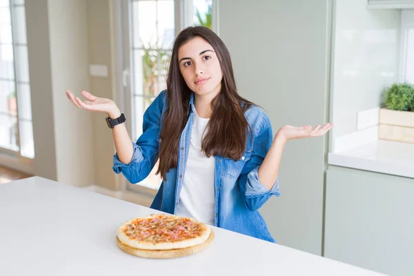 Vacker Ung Kvinna Äter Hemlagad Välsmakande Pizza Köket Clueless Och — Stockfoto