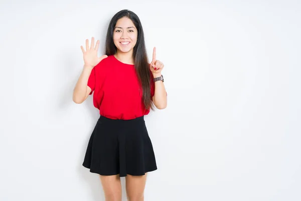 美丽的黑发女人穿着红色T恤和裙子在孤立的背景显示和指着手指六 同时微笑自信和快乐 — 图库照片