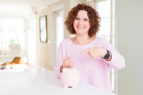 Senior Vrouw Geld Besparen Putting Een Munt Binnen Piggy Bank — Stockfoto