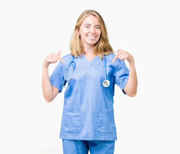 美丽的年轻医生妇女穿着医疗制服在孤立的背景看起来自信与微笑在脸上 用手指指向自己骄傲和快乐 — 图库照片
