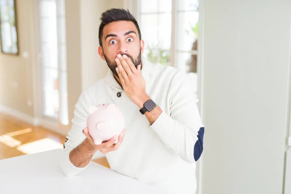 Stilig Spansktalande Man Innehar Spargris Täcka Munnen Med Hand Chockad — Stockfoto