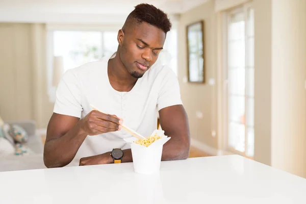 配達箱でアジアンヌードルを食べるハンサムなアフリカ人男性、スミ — ストック写真