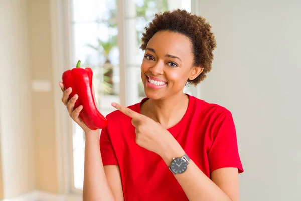 新鮮な赤唐辛子を持つ若いアフリカ系アメリカ人女性は 手と指で指差し非常に幸せ — ストック写真