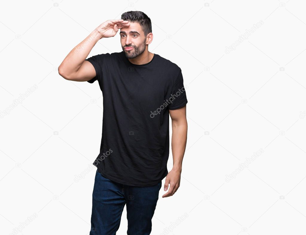 Young handsome man over isolated background very happy and smiling looking far away with hand over head. Searching concept.
