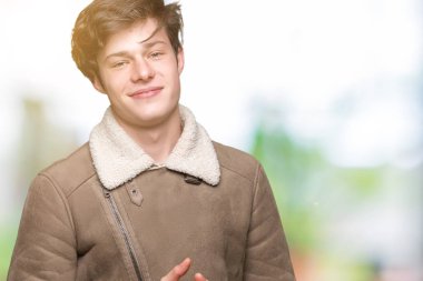 Arka plan eller üzerinde kış ceket giyen genç yakışıklı adam birlikte izole ve rahat ve neşeli gülümseyen parmak çarpı işareti. Başarı ve iyimser