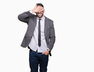 Genç yakışıklı iş adamı gülümsüyor ve gözleri için sürpriz kapsayan yüz el ile gülüyor izole arka plan üzerinde. Kör kavramı.