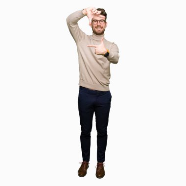 Elle yapma çerçeve ve parmakları ile mutlu yüz gülümseyen gözlüklü genç yakışıklı iş adamı. Yaratıcılık ve Fotoğrafçılık kavramı.