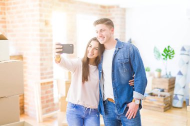Güzel genç çift akıllı telefon ile bir selfie fotoğrafı alarak mutlu gülümseyen, çok yeni bir eve hareket heyecanlı