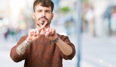 Eksi işareti yapıyor izole arka plan ret ifade geçiş parmakları üzerinde kış kazak giyen genç yakışıklı adam