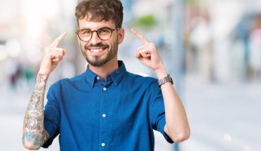 Hem el parmak, harika bir fikir ya da düşünce, iyi bellek ile baş gösteren gülümseyen genç yakışıklı adam gözlük izole üzerinde arka plan