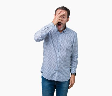 Mahcup ifadeyle parmaklarımın arasından görünen yüz ve gözler el ile kapsayan şok izole arka plan bakmak üzerinde yakışıklı orta yaş zarif üst düzey adam.