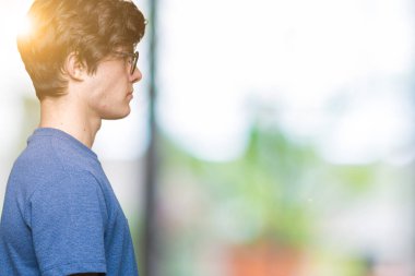 Genç yakışıklı adam gözlük izole arka tarafına, seyir üzerinde dinlenmek doğal yüz emin gülümseme ile pozuyla profili.