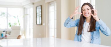 Evde beyaz masada oturan güzel genç kadının geniş açılı resmi öfkeden bıkmış bağırıyor, elleri boğmaya çalışıyor, deli gibi bağırıyor