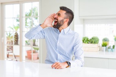 Yakışıklı İspanyol iş adamı bağırıyor ve ağızda el ile yan yüksek sesle bağırıyor. İletişim kavramı.