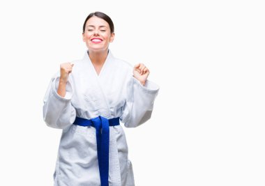Zafer kutluyor gülümseyen izole arka kolları olan başarı için heyecan üzerinde karate kimono üniforma giyen genç güzel kadın kaldırdı. Kazanan kavramı.