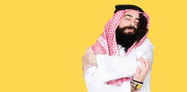 Arap iş adamı uzun saçlı geleneksel keffiyeh giyiyor emin gülümseyen Hugging kendini mutlu ve olumlu, eşarp. Kendi aşk ve öz bakım