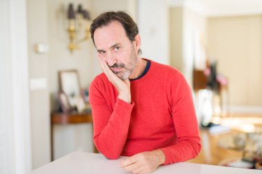 Yakışıklı orta yaş erkek evde seyir yorgun ve çapraz kolları olan depresyon sorunları ile sıkılmış düşünme.