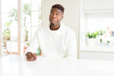 Yakışıklı afro-amerikan adam beyaz masada dudakları, çılgın ve komik jest ile balık yüz yapma. Komik ifade.