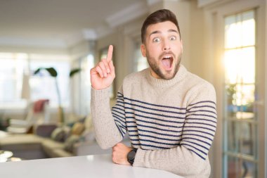 Evde Genç yakışıklı adam başarılı bir fikir ile parmak yukarı işaret. Çıkıldı ve mutlu. Bir numara.