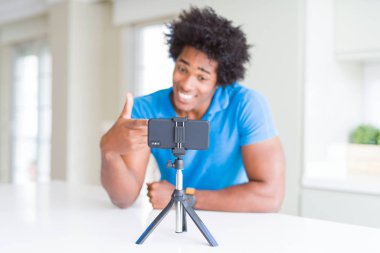 Afro-Amerikan adam el ve parmak ile işaret akıllı telefon kullanarak web kamerası ile online arama yapıyor