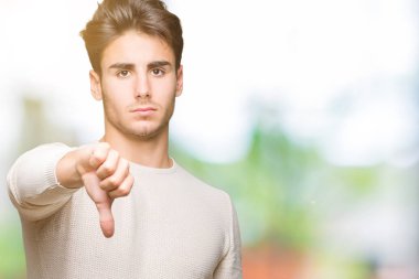 Yakışıklı delikanlı mutsuz ve kızgın ret gösterilen ve başparmak aşağı hareketi ile negatif seyir izole arka plan üzerinde. Kötü ifade.