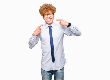 Genç yakışıklı iş adamı ile kendine güvenen gösterilen ve işaret parmakları diş ve ağız ile gülümseyen gözlüklü afro. Sağlık kavramı.