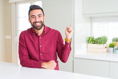 Yüzünde büyük bir gülümseme ile Yakışıklı İspanyol iş adamı, kameraya bakarak yan el ve parmak ile işaret.