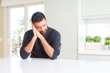 Yakışıklı İspanyol adam evde rahat kazak giyen yorgun rüya ve kapalı gözlerle gülümseyerek birlikte elleri ile poz uyku.