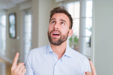 Yakışıklı iş adamı şaşırtmak ve yukarıya bakıp parmakları ile işaret şaşırttı ve silah kaldırdı.