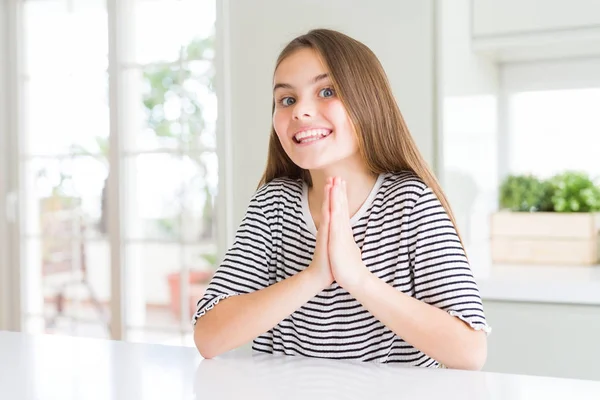 美しい若い女の子の子供は 自信を持って許しを求めて手で祈るストライプTシャツを着て — ストック写真