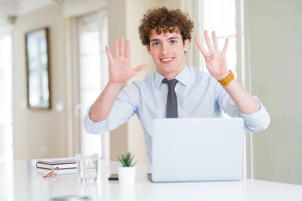 オフィスでコンピュータラップトップで働く若いビジネスマンは 自信を持って幸せに微笑みながら 指番号9を示し 指を上げる — ストック写真