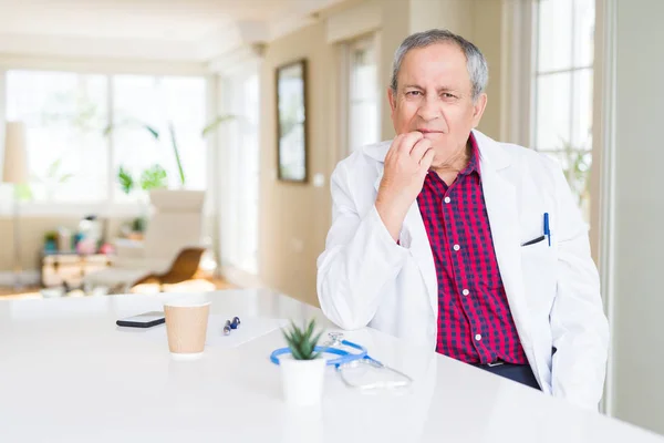 Przystojny Starszy Lekarz Człowiek Nosi Płaszcz Medyczny Klinice Patrząc Zestresowany — Zdjęcie stockowe