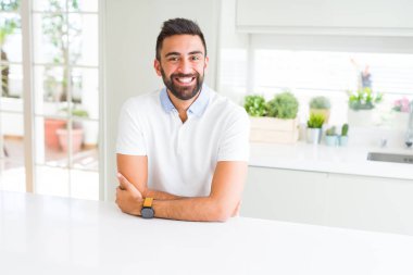 Yakışıklı İspanyol ile mutlu yüz gülümseyerek kameraya seyir silah geçti casual beyaz t-shirt evde dostum. Olumlu bir kişi.
