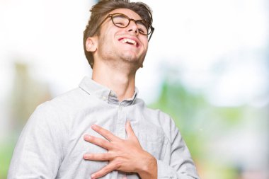 Genç yakışıklı adam gözlük izole üzerinde arka plan gülen ve komik deli şaka çünkü yüksek sesle zor gülüyor. Mutlu ifade.