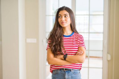 Görünümlü yan ve dik dik bakma uzağa düşünce gülümseyen rahat t-shirt giyen genç güzel kadın.