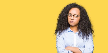 Genç güzel iş kız gözlük şüpheci ve sinir, onaylamayan ifade yüz çapraz kollu giyiyor kıvırcık saçlı. Negatif kişi.