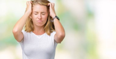 Çünkü çaresiz ve stresli baş ağrısı acı izole arka plan üzerinde rahat beyaz t-shirt giyen güzel genç kadın acı ve Migren. Ellerini kafasına.