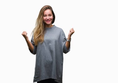 Genç güzel sarışın kadın kutluyor izole arka plan üzerinde şaşırttı ve başarı için kaldırdı kollarını açarak hayret ve gözleri açık. Kazanan kavramı.